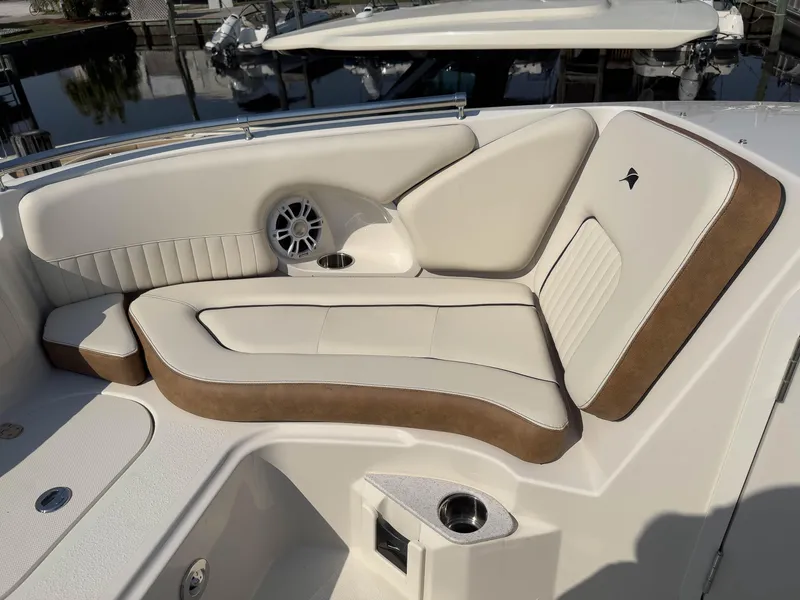 Slide: The Image of 2024 Stingray 211DC boat interior with beige and brown seating, cup holder, and speaker. - 25