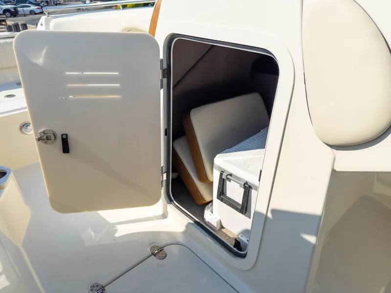 Slide: The Image of 2024 Stingray 211DC boat storage compartment with open door, revealing interior space. - 28