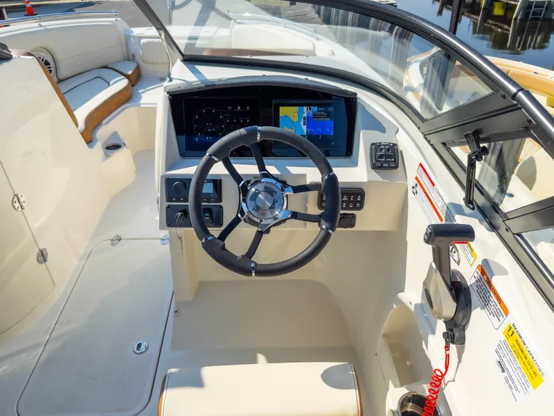 Slide: The Image of 2024 Stingray 211DC boat cockpit with steering wheel and navigation display. - 30