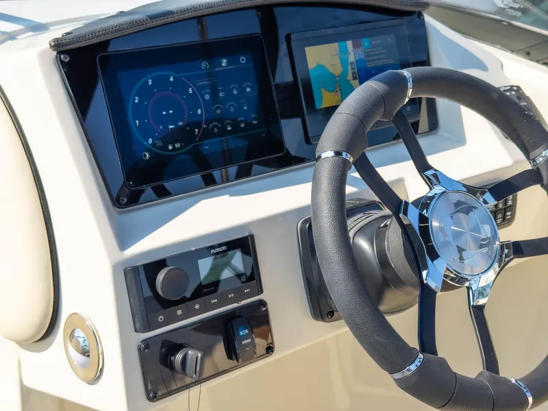 Slide: The Image of 2024 Stingray 211DC boat dashboard with modern steering wheel and digital displays. - 31
