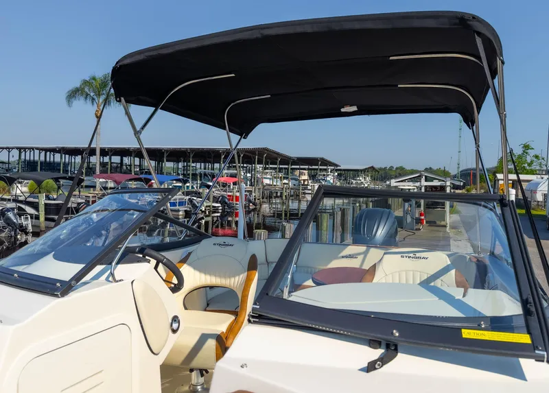 Slide: The Image of 2024 Stingray 211DC boat with canopy at marina dock. - 33