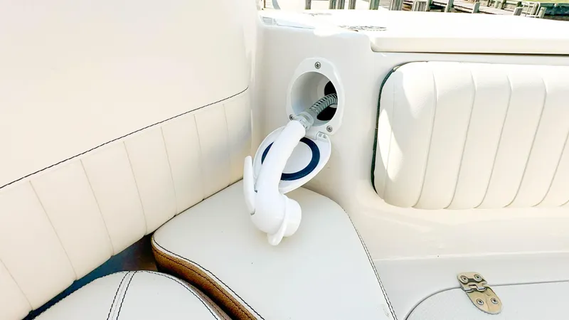Slide: The Image of 2024 Stingray 211DC boat interior with white seating and built-in shower hose. - 34