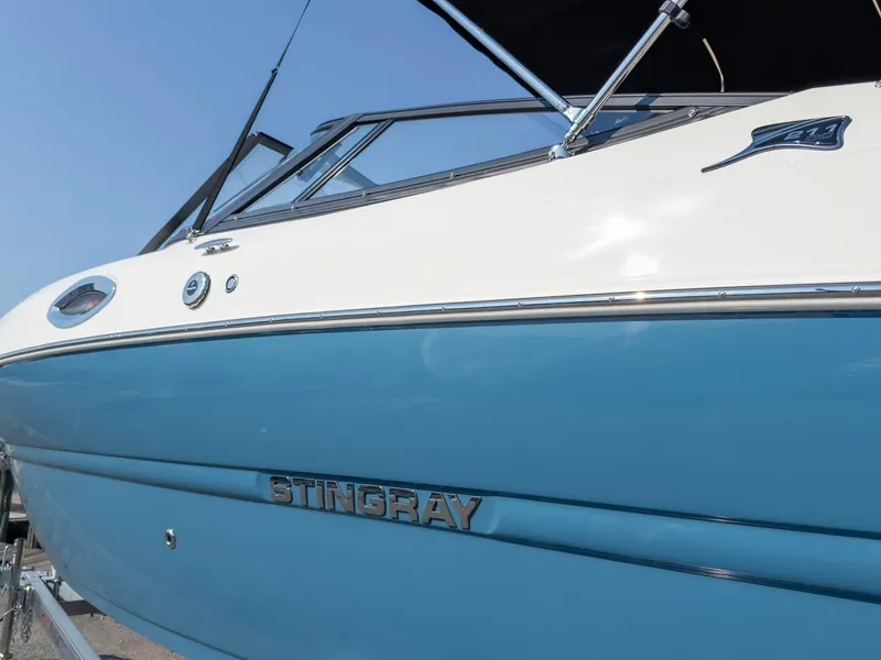 Slide: The Image of 2024 Stingray 211DC boat with blue and white exterior, side view. - 5