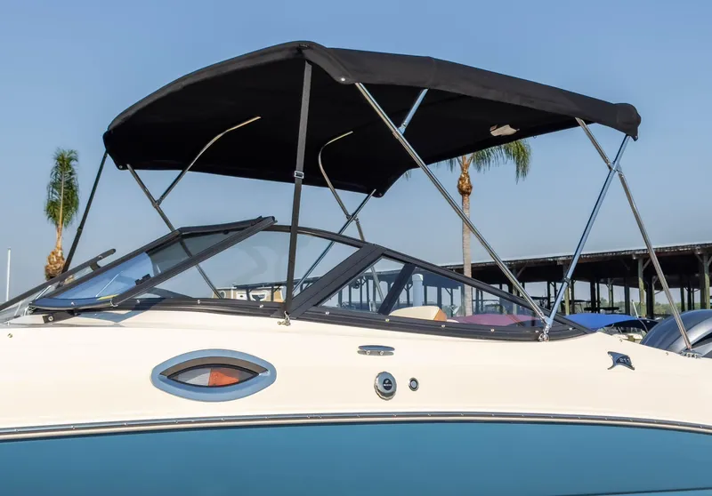 Slide: The Image of 2024 Stingray 211DC boat with black canopy and sleek design. - 7