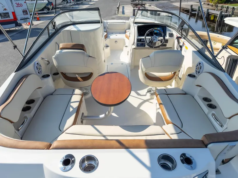 Slide: The Image of 2024 Stingray 211DC boat interior with seating, table, and steering console. - 9