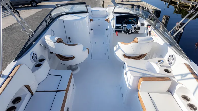 Slide: The Image of 2025 Stingray 231DC boat interior with white seating and modern dashboard. - 10