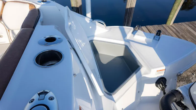 Slide: The Image of 2025 Stingray 231DC boat interior with storage compartment and cup holders. - 15