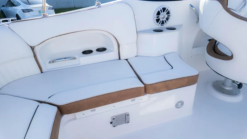 Slide: The Image of 2025 Stingray 231DC boat interior with white and brown seating, cup holders, and speaker. - 20