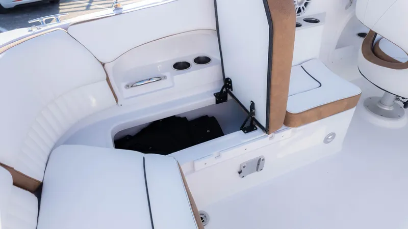 Slide: The Image of 2025 Stingray 231DC boat interior with open storage compartment and cushioned seating. - 21