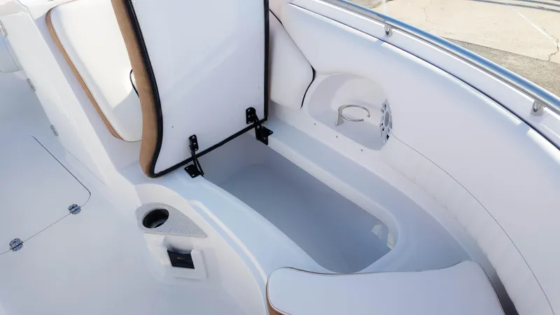 Slide: The Image of 2025 Stingray 231DC boat interior with open storage compartment and cup holder. - 23
