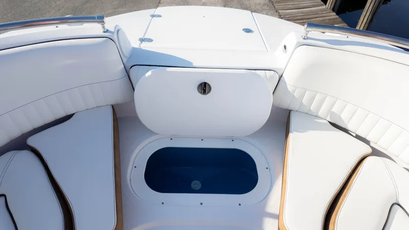 Slide: The Image of 2025 Stingray 231DC boat interior with white seating and storage compartment. - 25
