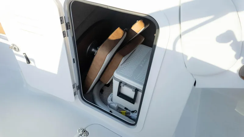Slide: The Image of Storage compartment in 2025 Stingray 231DC boat with cushions and cooler. - 26