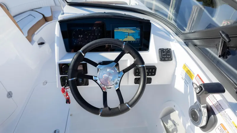 Slide: The Image of 2025 Stingray 231DC boat dashboard with steering wheel and navigation display. - 29