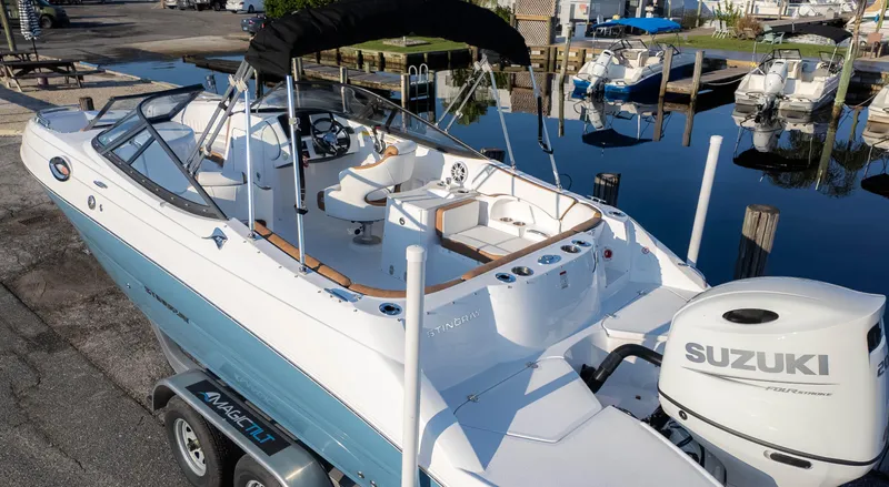 Slide: The Image of 2025 Stingray 231DC boat with Suzuki engine docked at marina. - 5