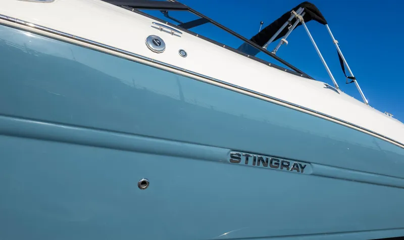 Slide: The Image of 2025 Stingray 231DC boat side view with logo against clear blue sky. - 6