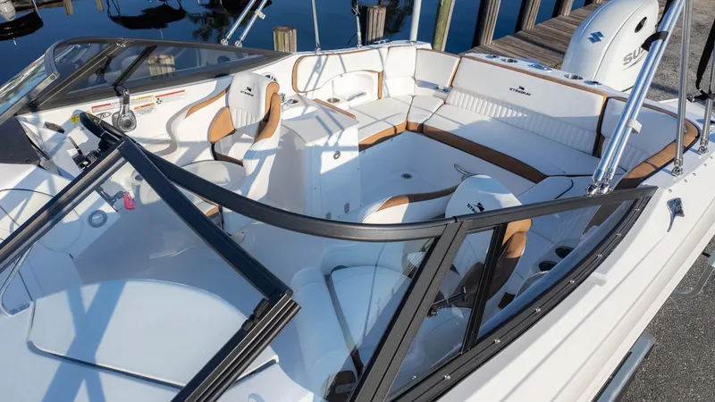Slide: The Image of 2025 Stingray 231DC boat interior with white and tan seating, sleek design, and modern features. - 9