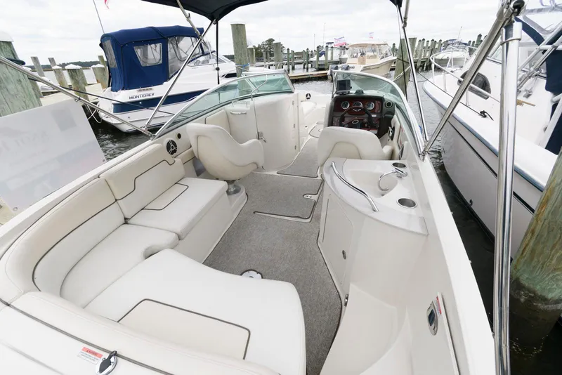 Slide: The Image of 2008 Sea Ray 260 Sundeck boat interior with spacious seating and helm, docked at marina. - 2
