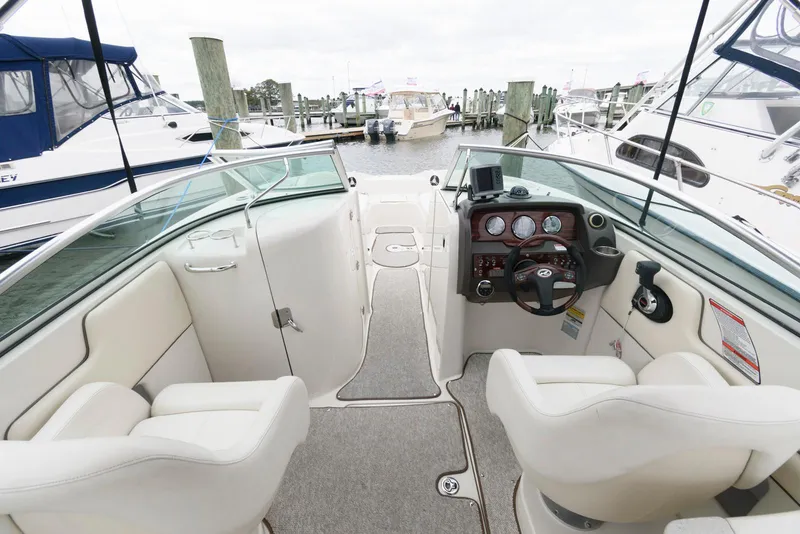 Slide: The Image of 2008 Sea Ray 260 Sundeck interior with helm, seating, and marina view. - 3