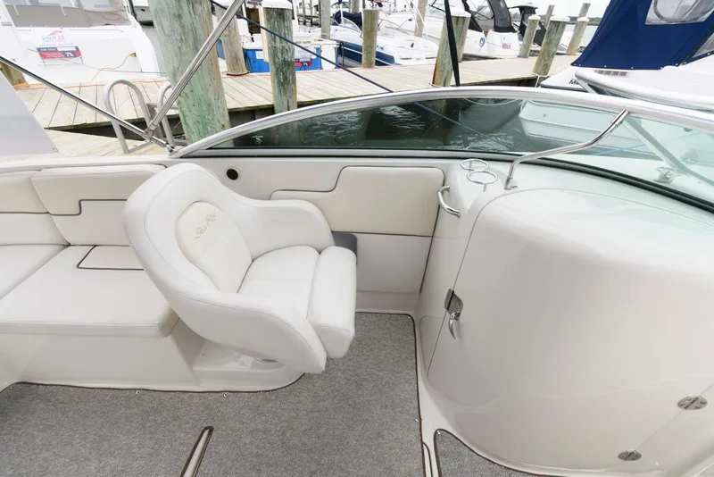 Slide: The Image of 2008 Sea Ray 260 Sundeck interior with white seating and dock view. - 7