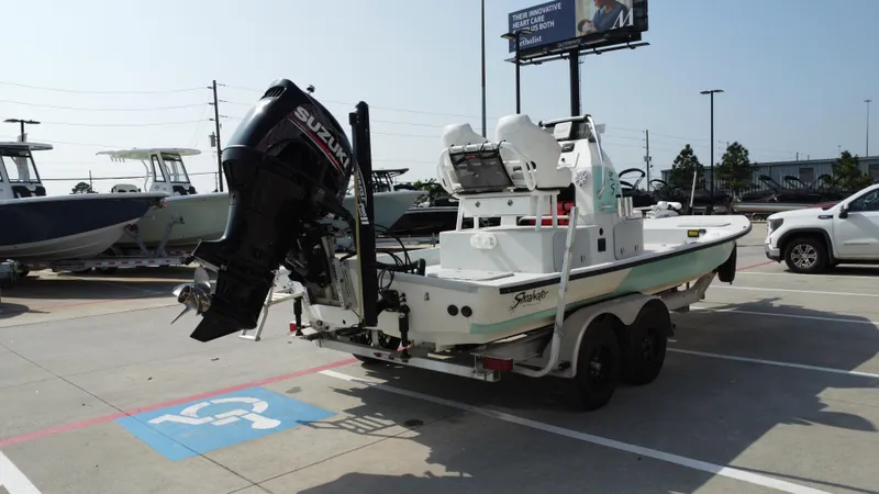 Slide: The Image of 2018 Shoalwater 21 CAT DLX boat on trailer with Suzuki outboard motor in parking lot. - 10