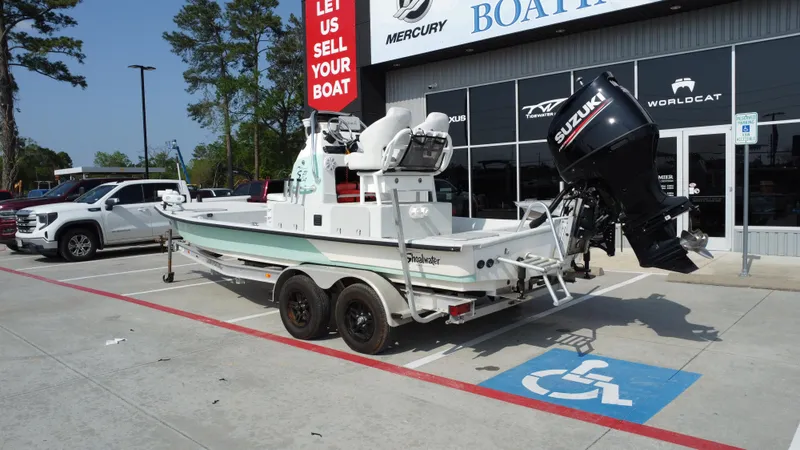Slide: The Image of 2018 Shoalwater 21 CAT DLX boat on trailer outside dealership, featuring Suzuki outboard motor. - 3