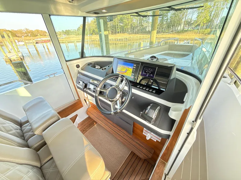 Slide: The Image of 2019 Axopar 28 CABIN interior with modern dashboard and scenic water view. - 12