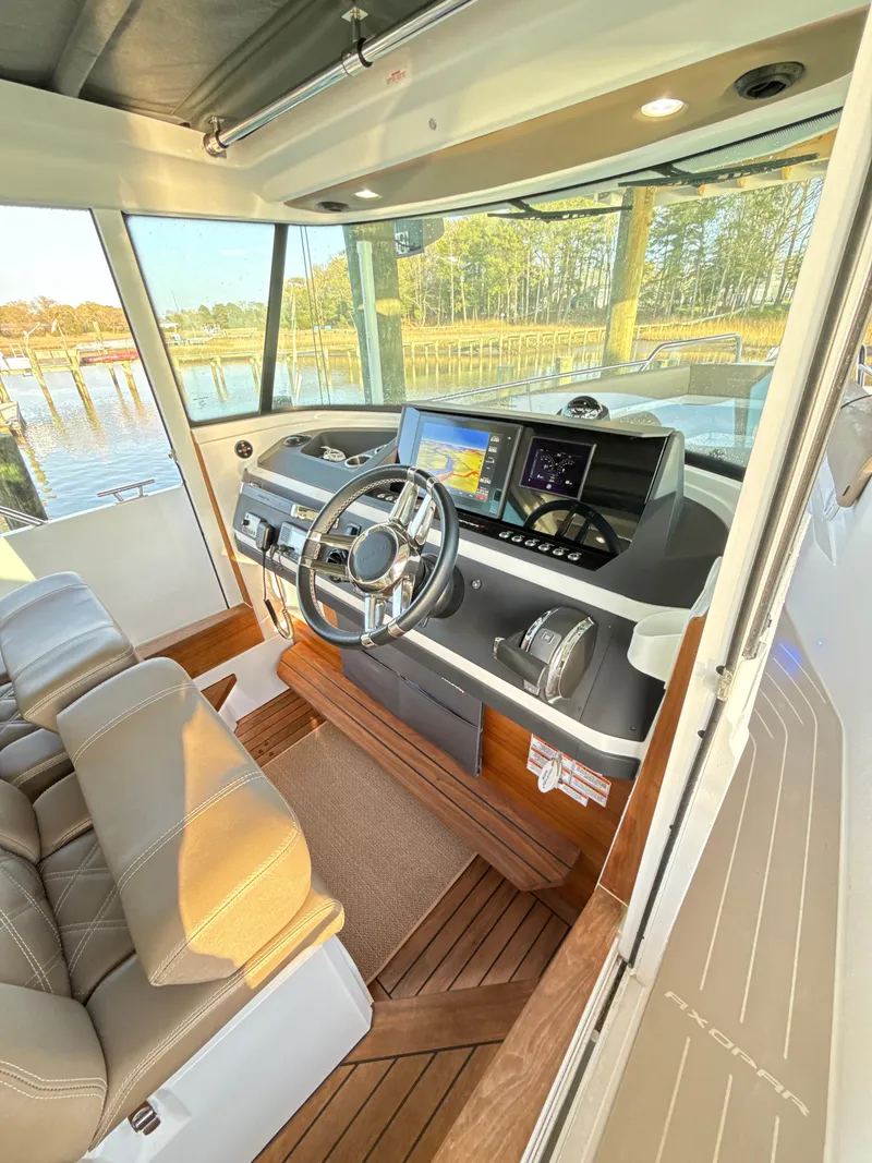 Slide: The Image of 2019 Axopar 28 CABIN interior with modern dashboard and steering wheel. - 19