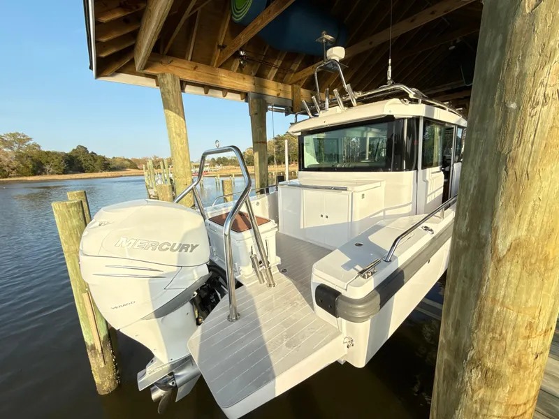 Slide: The Image of 2019 Axopar 28 CABIN boat docked with Mercury outboard engine. - 2