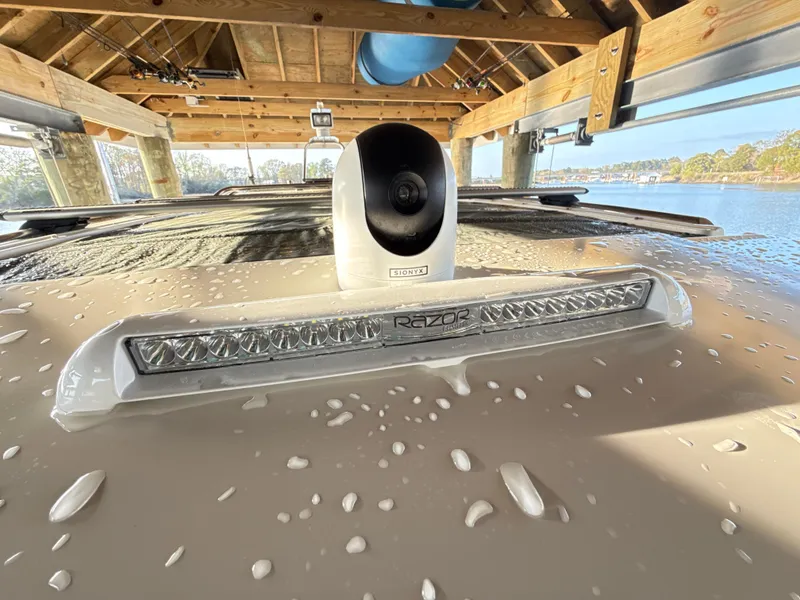 Slide: The Image of 2019 Axopar 28 CABIN with camera and light bar under a wooden dock. - 27