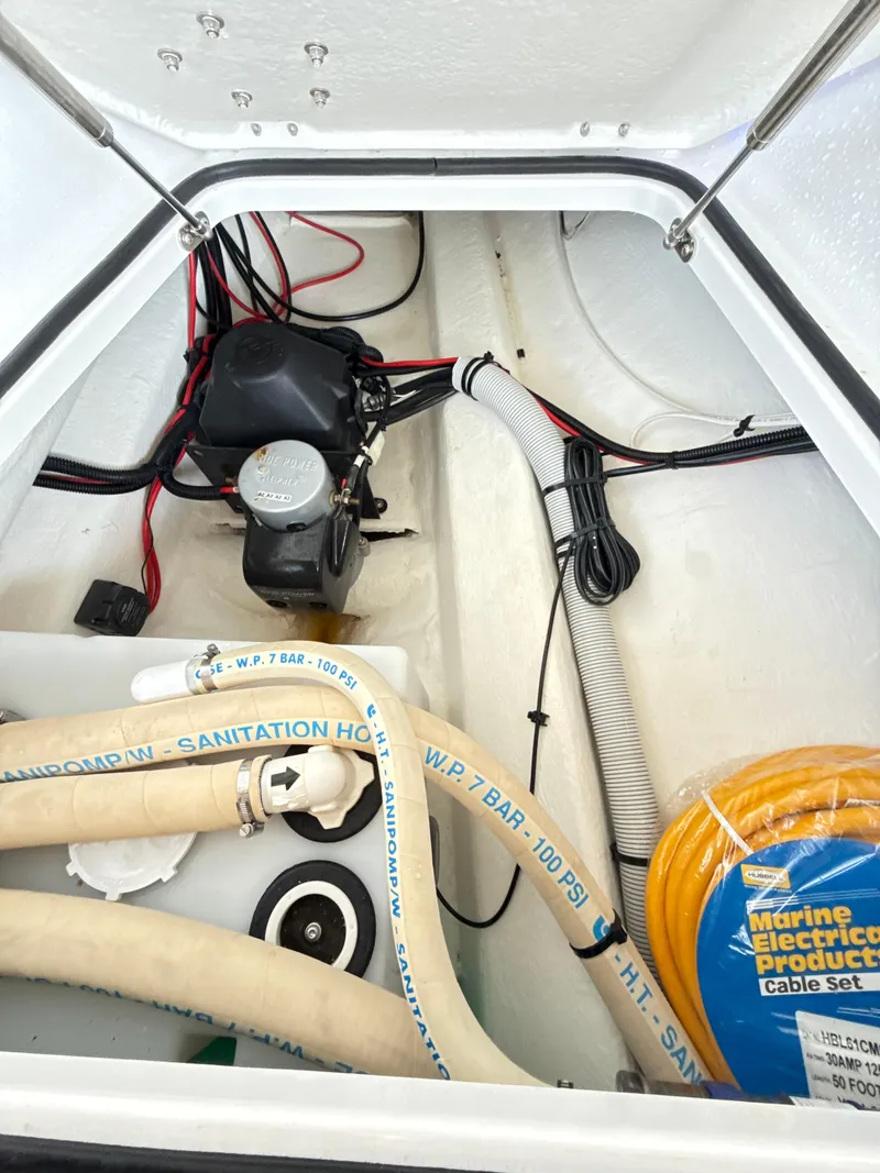 Slide: The Image of 2019 Axopar 28 CABIN storage compartment with cables and marine equipment. - 36