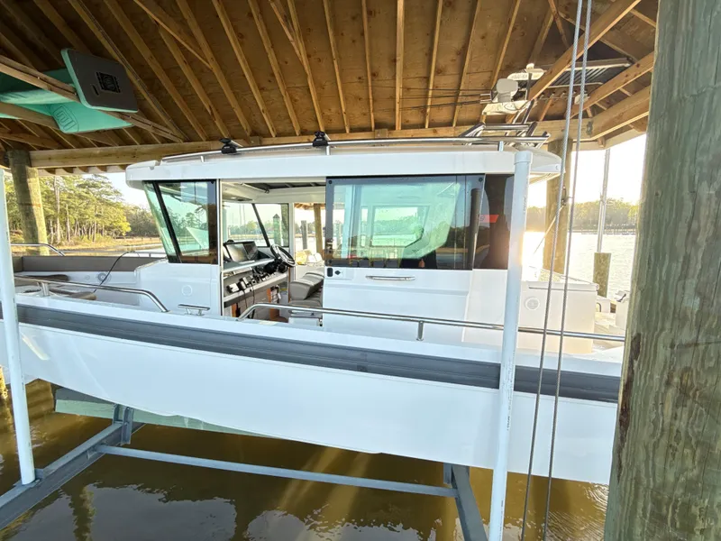 Slide: The Image of 2019 Axopar 28 CABIN boat docked under wooden shelter. - 4
