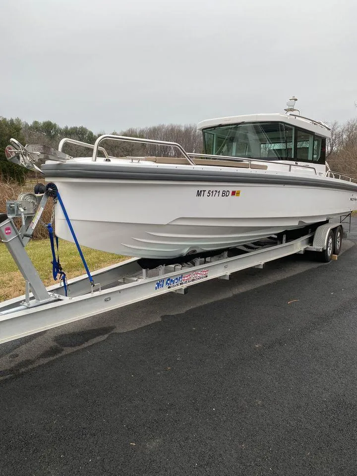 Slide: The Image of 2019 Axopar 28 CABIN boat on trailer, parked on asphalt road. - 43