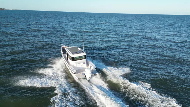 Slide: The Image of 2019 Axopar 28 CABIN cruising on open sea, creating waves. - 45