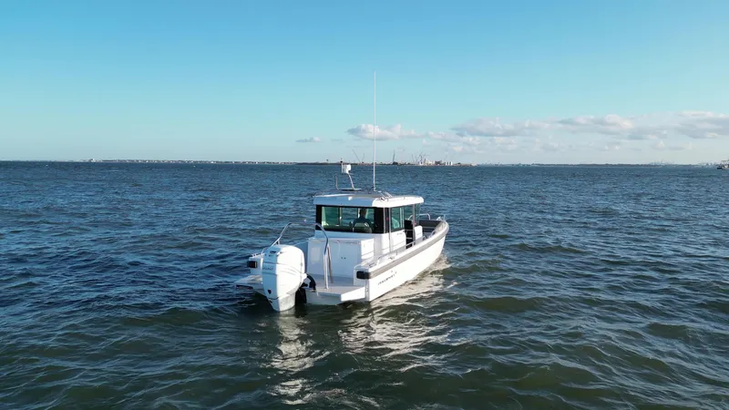Slide: The Image of 2019 Axopar 28 CABIN boat cruising on open water under clear skies. - 46