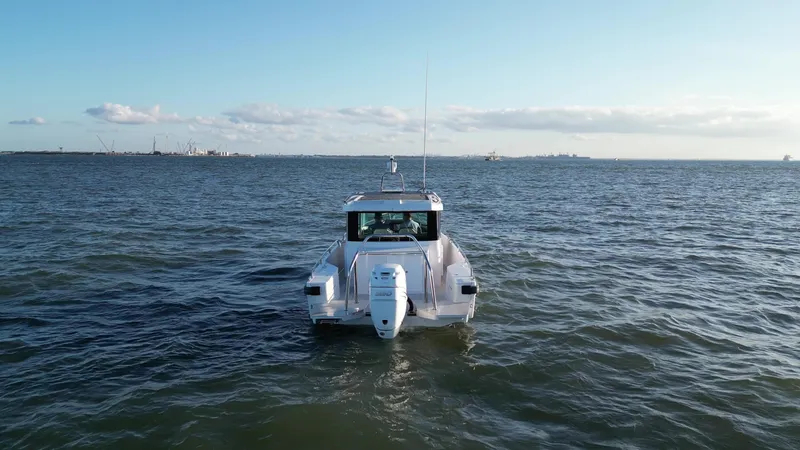 Slide: The Image of 2019 Axopar 28 CABIN boat on open water, viewed from the rear. - 47