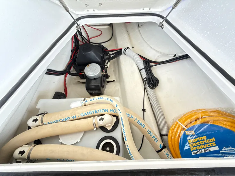 Slide: The Image of 2019 Axopar 28 CABIN boat storage compartment with hoses and electrical cables. - 48