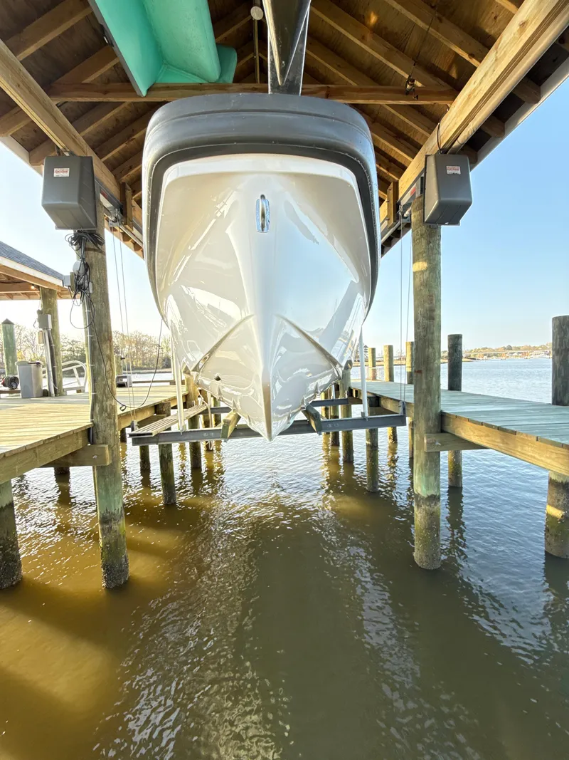 Slide: The Image of 2019 Axopar 28 CABIN boat docked under wooden shelter. - 7