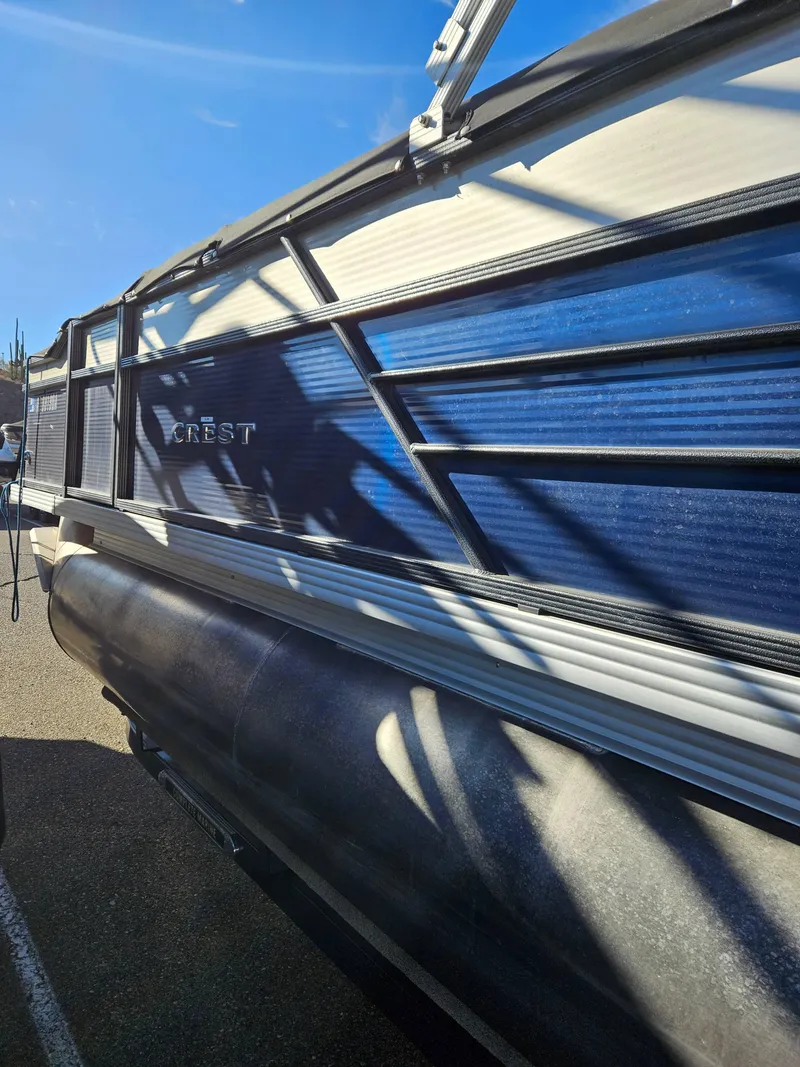 Slide: The Image of 2018 Crest 200 CA pontoon boat with blue and white exterior under clear sky. - 4