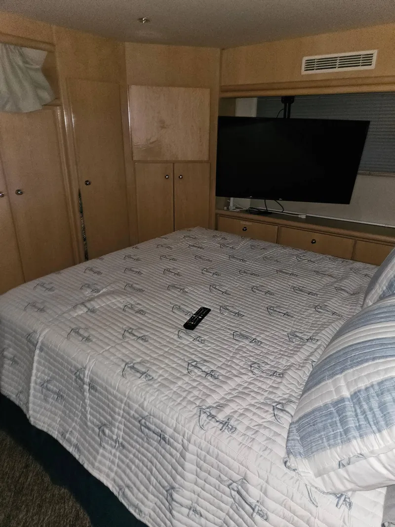 Slide: The Image of Interior of 1997 Carver 455 Aft Cabin Motoryacht bedroom with bed, TV, and remote control. - 17