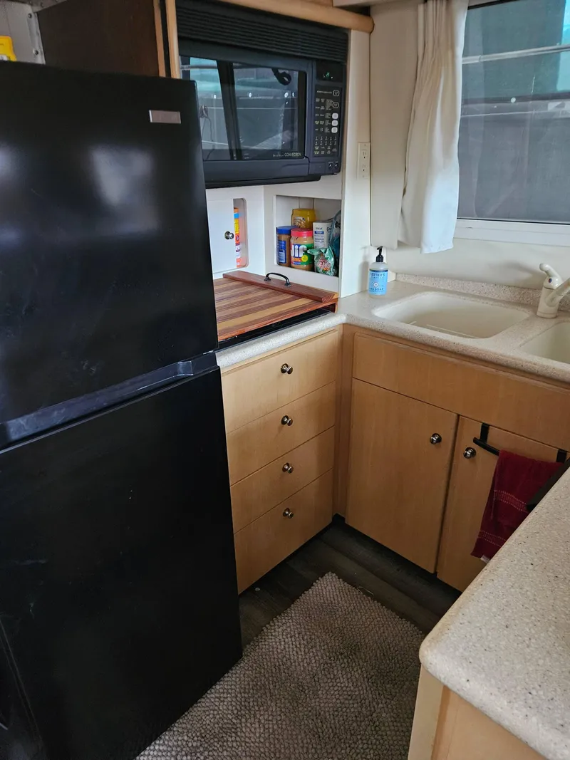 Slide: The Image of Compact kitchen in a 1997 Carver 455 Aft Cabin Motoryacht with fridge, microwave, and sink. - 9