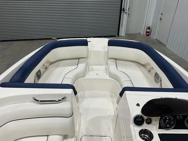 Slide: The Image of 2016 Bayliner 190 Deck Boat interior with white and blue seating, dashboard, and controls. - 10