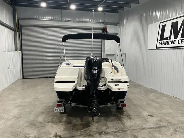 Slide: The Image of 2016 Bayliner 190 Deck Boat in a garage, rear view with outboard motor. - 4