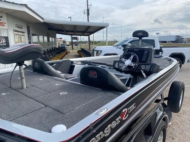 Slide: The Image of 2019 Ranger Z518 boat with seating and steering console, parked outdoors near a dealership. - 8