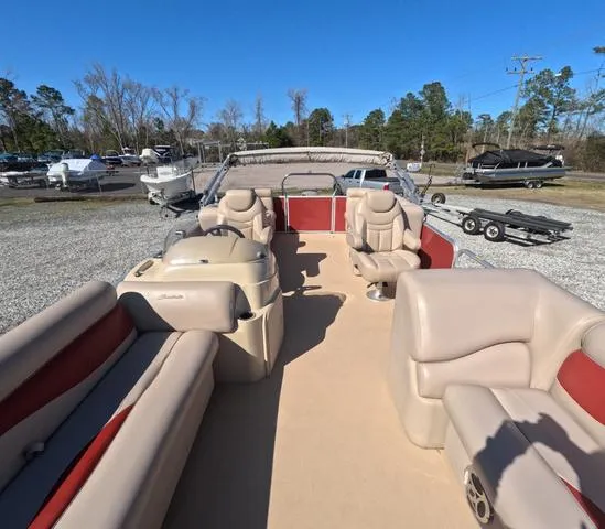 Slide: The Image of 2015 Sweetwater SW 2286 SLC pontoon boat with beige and red seating, parked outdoors. - 23