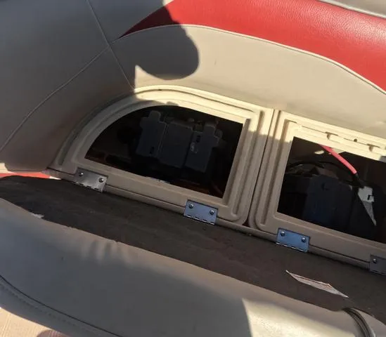 Slide: The Image of 2015 Sweetwater SW 2286 SLC boat seat storage compartment with visible battery setup. - 27