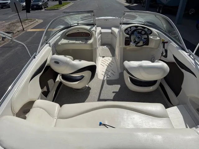 Slide: The Image of 2007 Tahoe Q7i boat interior with white seating and steering wheel, parked on pavement. - 4