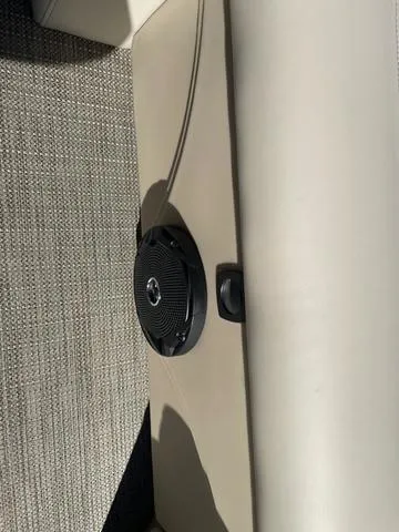 Slide: The Image of 2025 Bentley Pontoons 223 Legacy Swingback interior speaker detail on beige upholstery. - 18