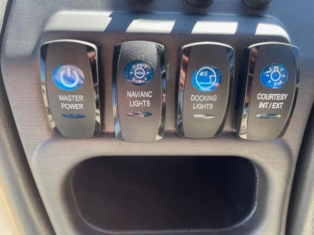 Slide: The Image of Control panel of 2025 Bentley Pontoons 223 Legacy Swingback with labeled switches for various lights. - 8