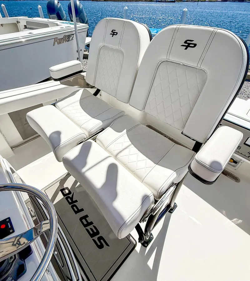 Slide: The Image of 2023 Sea Pro 219 Center Console boat with luxurious white seating and ocean backdrop. - 10