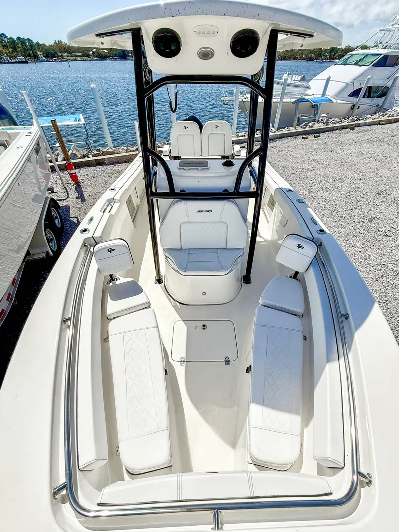 Slide: The Image of 2023 Sea Pro 219 Center Console boat with spacious seating, docked by the water. - 12